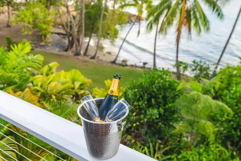 Champagne bottle in an ice bucket on the balcony railing at Havana Port Douglas overlooking the beach and Coral Sea