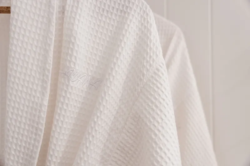 Close-up of a white waffle-weave bathrobe with embroidered logo at Havana, Port Douglas