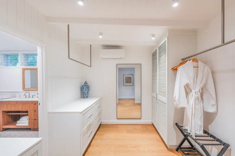 Spacious walk-in wardrobe and dressing room at Havana Port Douglas with white cabinetry, full-length mirror, robe, and ensuite entry